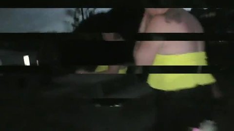Ocean in yellow top with giant LED tail plug walks beach at night