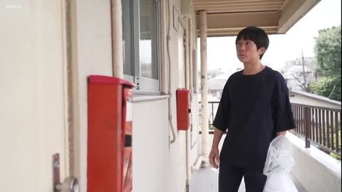 Tall Japanese man in black shirt on balcony holding plastic bag, JAV style