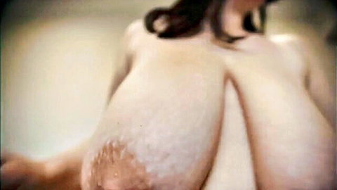 Curvy pale woman with massive tits posing nude from behind