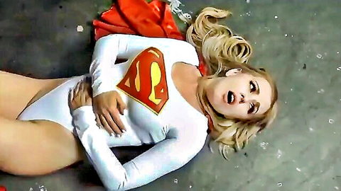 Blonde superheroine in tight white costume lying distressed on floor