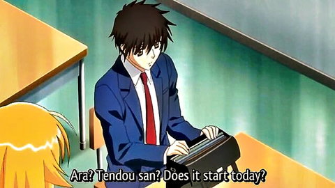 Anime boy in blue suit types at desk while orange-haired girl leans over asking Tendo-san if it starts today