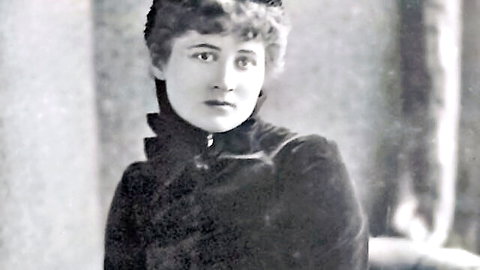 Vintage portrait of elegant woman in high-collar black velvet dress with curly hair