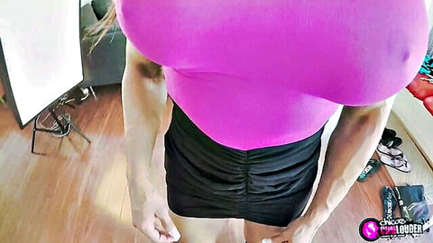 Karyn Bayres FBB poses in tight pink top and black skirt showing muscles