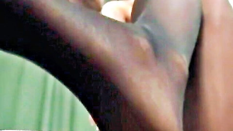 Ebony goddess feet in sheer black stockings, close-up leg worship tease