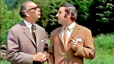 Vintage suited men conversing outdoors in classic 70s style