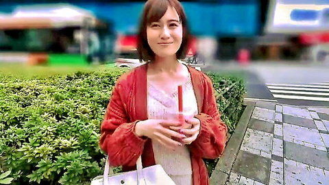 Smiling Japanese woman in red cardigan holding pink drink outdoors, JAV style
