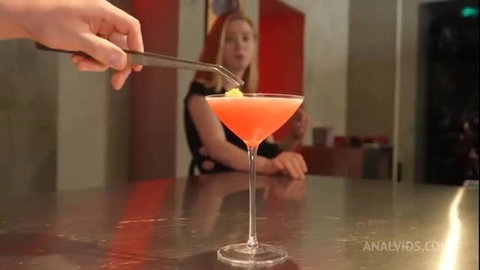 Crystal White at bar with pink cocktail and lemon twist garnish