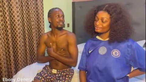 Ebony General shirtless with busty Chelsea fan girl on bed, amateur tease