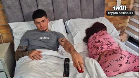Alejandra Palacios in pink lingerie next to tattooed guy in bed, crypto casino promo