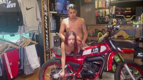 Antonella Riva nude on red Yamaha bike, guy groping her in shop