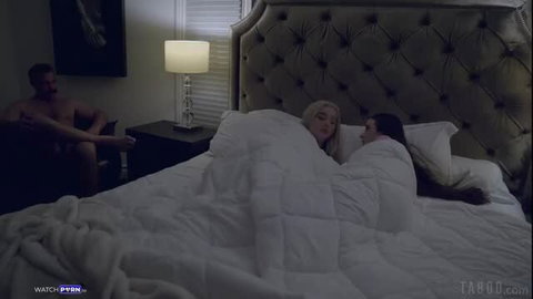 Lexi Lore and Hazel Moore cuddling nude in bed, watched by Charles Dera