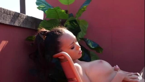 Dazzling Asian babe naked on roof, big tits exposed, seductive pose