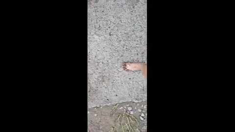 Dirty bare feet walking on beach sand shown on street