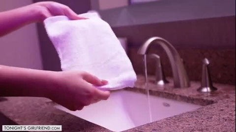 Dolly Paige holding white towel at sink in hotel bathroom