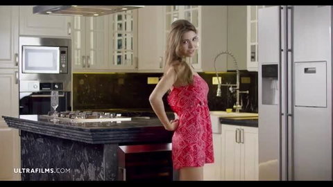 Curvy brunette in tight red dress poses in kitchen, big naturals