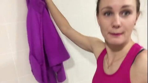 Ivi Roses holding purple jacket in gym locker room tank top