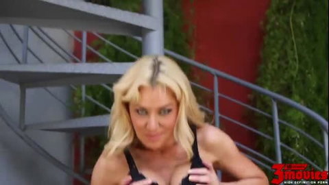 Blonde bombshell in black lingerie teases on spiral staircase
