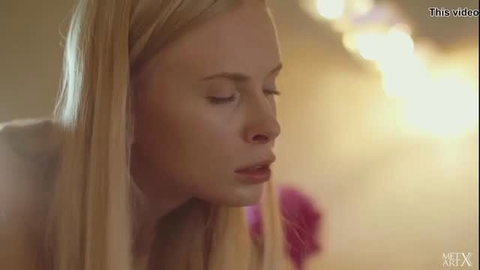 Blonde beauty with sensual lips in soft-lit tease