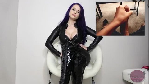 Goddess Valora in latex catsuit and boots, dominant femdom pose