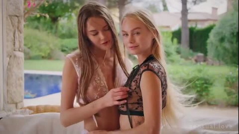 Nancy A in lace lingerie adjusting Sonya Blaze's black lace top poolside