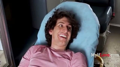 Nick Strokes smiles in pink shirt on blue pillow in Paramedics Fix Blue Balls