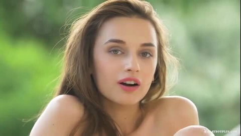 Nude beauty with stunning natural breasts squeezes them softly outdoors