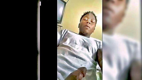 Black guy lying back stroking his dick in amateur home video