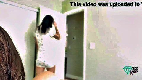Nikki Zee teasing in white romper, looking back seductively from door frame