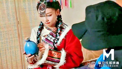 Asian beauty in traditional ethnic attire holding blue vase, seductive solo pose