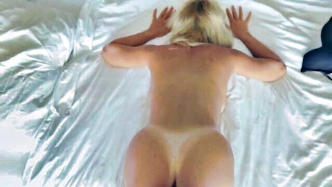 Blonde woman lying nude face down on bed in roommate surprise