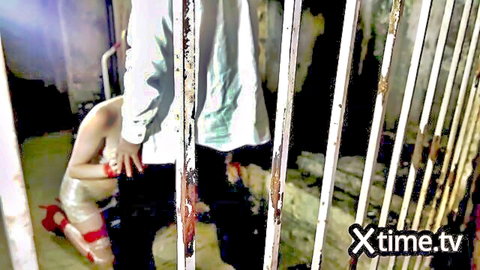 Naked BDSM slut kneels in cage exposing wet pussy and ass to man with huge erect cock through bars
