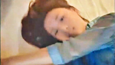 Young Chinese woman from Suzhou lying sideways on bed in casual blue top