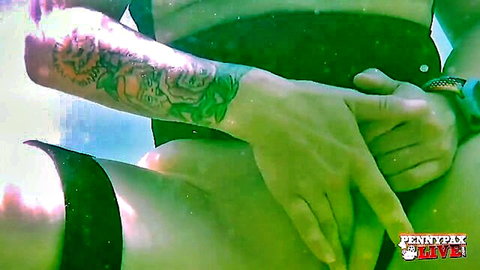 Penny Pax underwater in black bikini, tattooed arms teasing thighs