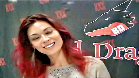 Smiling redhead MILF with cleavage in sparkly top at BKD Red Dragon event