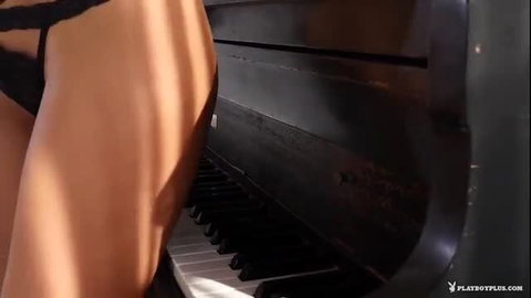Tanned Playboy babe in black thong bends over grand piano, teasing ass