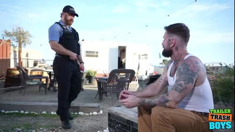 Officer Brogan in uniform talks to tattooed Troy Daniels at Trailer Trash Boys