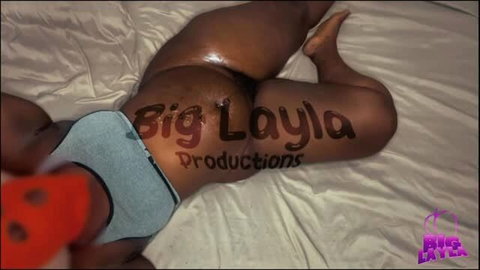 Big Layla Productions model showing oiled ass in thong on bed