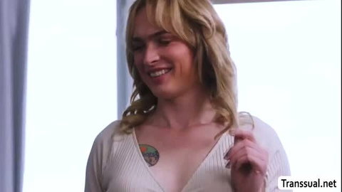 TS Blake smiling in sheer top, long blonde hair, tattoo visible