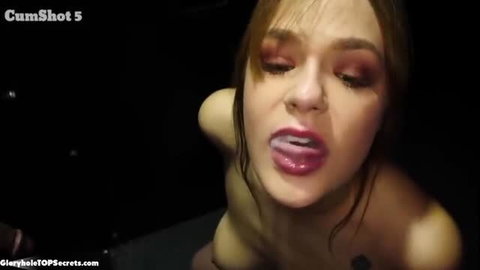 Busty brunette with glossy lips receiving gloryhole cumshot on face