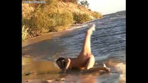 Lilya A nude on beach with legs raised in water, MetArt outdoor video
