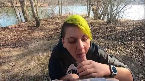 Woman with neon green hair gives outdoor blowjob and swallows cum by the lake