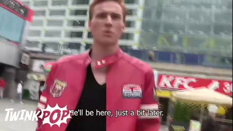 Redhead twink in pink bomber jacket standing outdoors