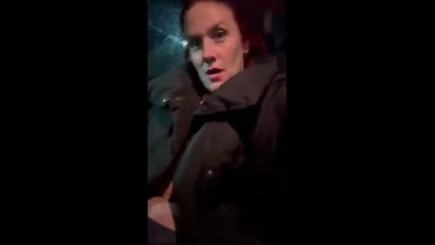 Woman in coat outdoors at night with mouth open