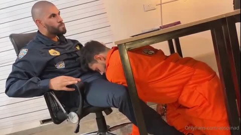 Alejo Ospina in orange jumpsuit giving oral in police station scene
