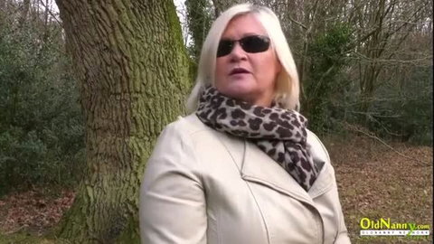 Lacey Starr in sunglasses and leather jacket standing by tree