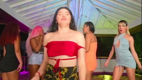 Group of women dancing in sexy club outfits, red top center focus