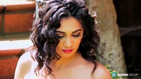 Alexya topless with dark curly hair, seductive gaze
