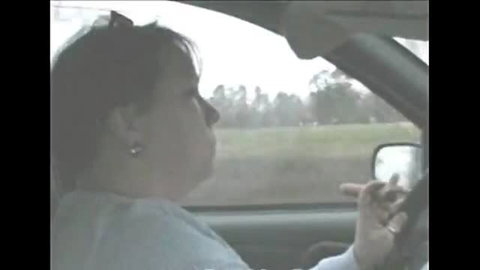 Mature woman smoking huge cigar while driving