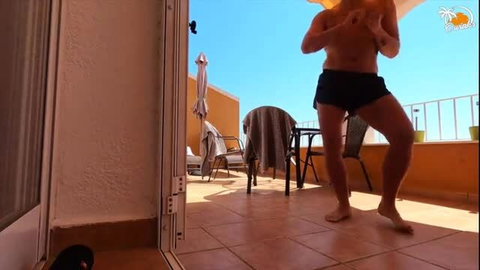 Naked man dancing on sunny Spanish balcony