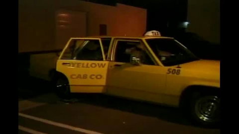 Vintage yellow taxi cab at night with two women inside